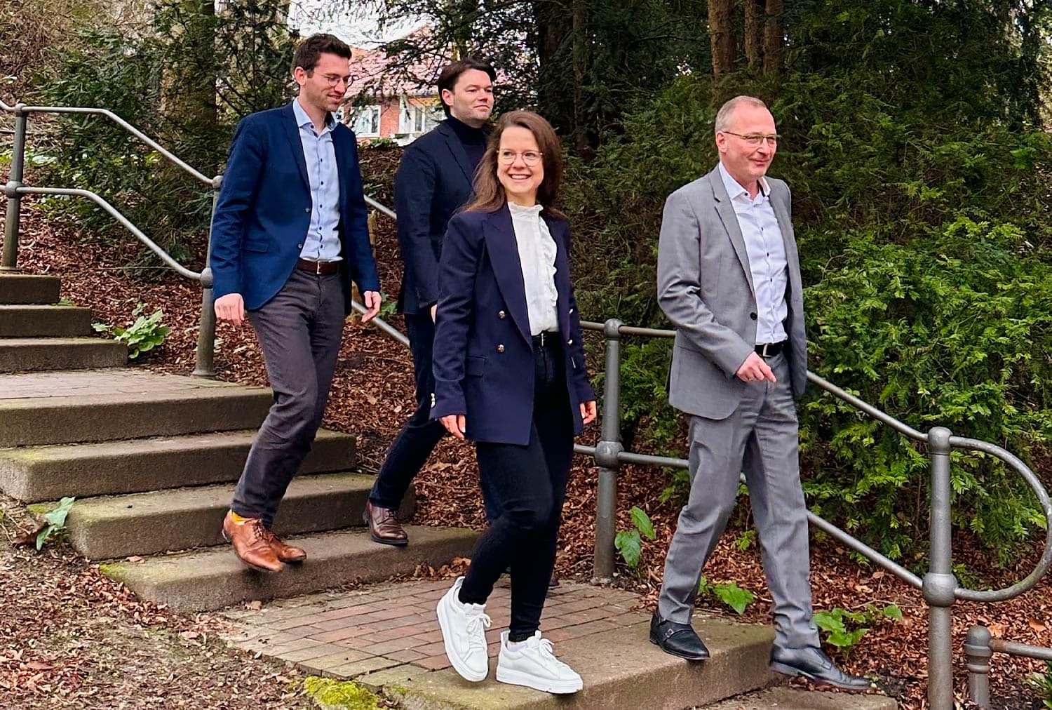 Team der HLB S&G Consulting GmbH, Nachhaltigkeitsberatung, auf einer Treppe im Grünen